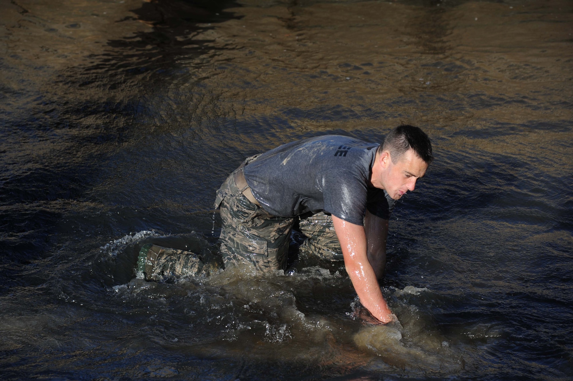 Airman Sean Cummins, 334th Training Squadron, pushes himself up after jumping into the water from a cement pillar during the combat controllers’ physical training session April 12, 2013, on Biloxi beach.  Combat controllers are ground troops who are embedded with special forces teams and provide close-air support for special forces units. While at Keesler, trainees learn how to run, swim, carry a rucksack and conduct air traffic control. These Airmen are prepared physically and mentally for the demands of the combat controller pipeline while earning air traffic control certification in just 15 weeks.  (U.S. Air Force photo by Kemberly Groue)