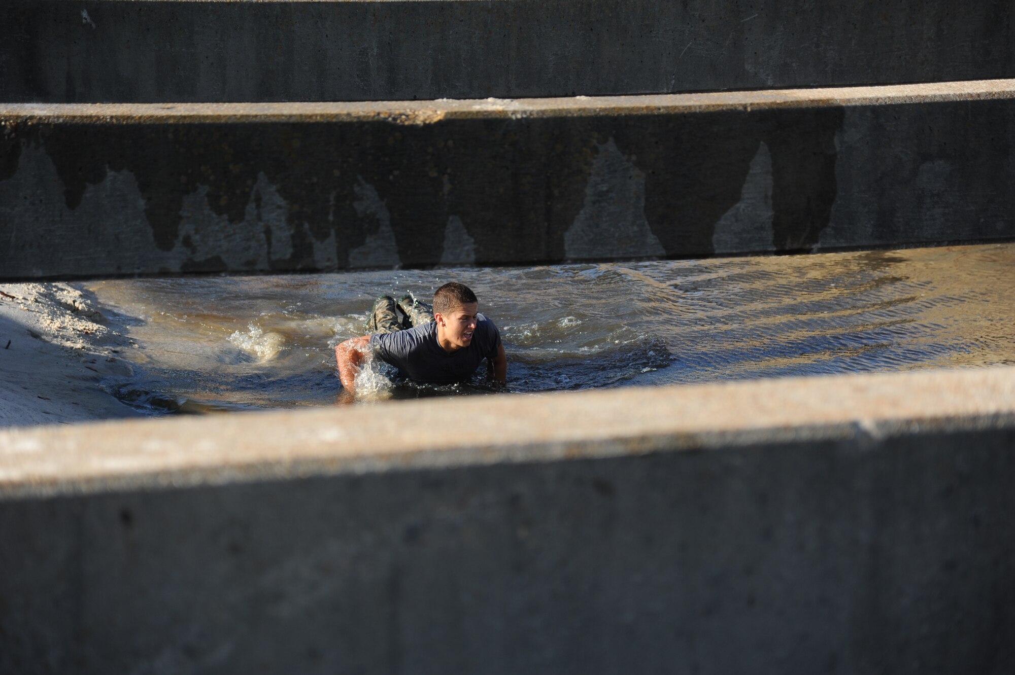 Airman 1st Class Jordan Smith, 334th Training Squadron, jumps into the water from a cement pillar during the combat controllers’ physical training session April 12, 2013, on Biloxi beach.  Combat controllers are ground troops who are embedded with special forces teams and provide close-air support for special forces units. While at Keesler, trainees learn how to run, swim, carry a rucksack and conduct air traffic control. These Airmen are prepared physically and mentally for the demands of the combat controller pipeline while earning air traffic control certification in just 15 weeks.  (U.S. Air Force photo by Kemberly Groue)