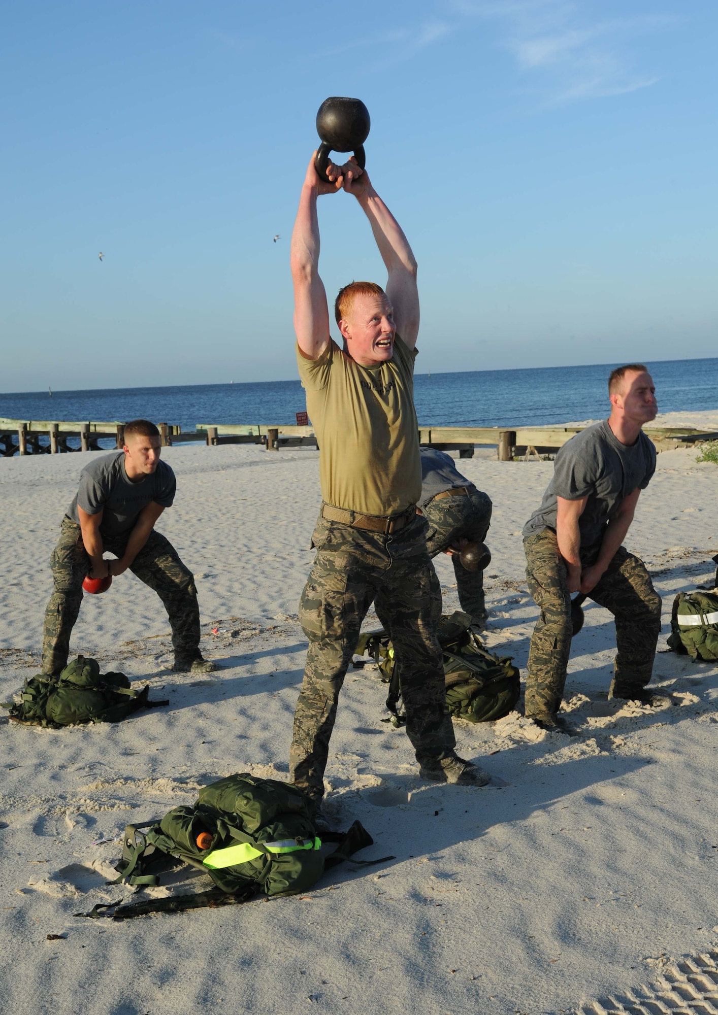 Second Lt. Eric Soderberg, 334th Training Squadron, lifts a kettlebell over his head during the combat controllers’ physical training session April 12, 2013, on Biloxi beach.  Combat controllers are ground troops who are embedded with special forces teams and provide close-air support for special forces units. While at Keesler, trainees learn how to run, swim, carry a rucksack and conduct air traffic control. These Airmen are prepared physically and mentally for the demands of the combat controller pipeline while earning air traffic control certification in just 15 weeks.  (U.S. Air Force photo by Kemberly Groue)