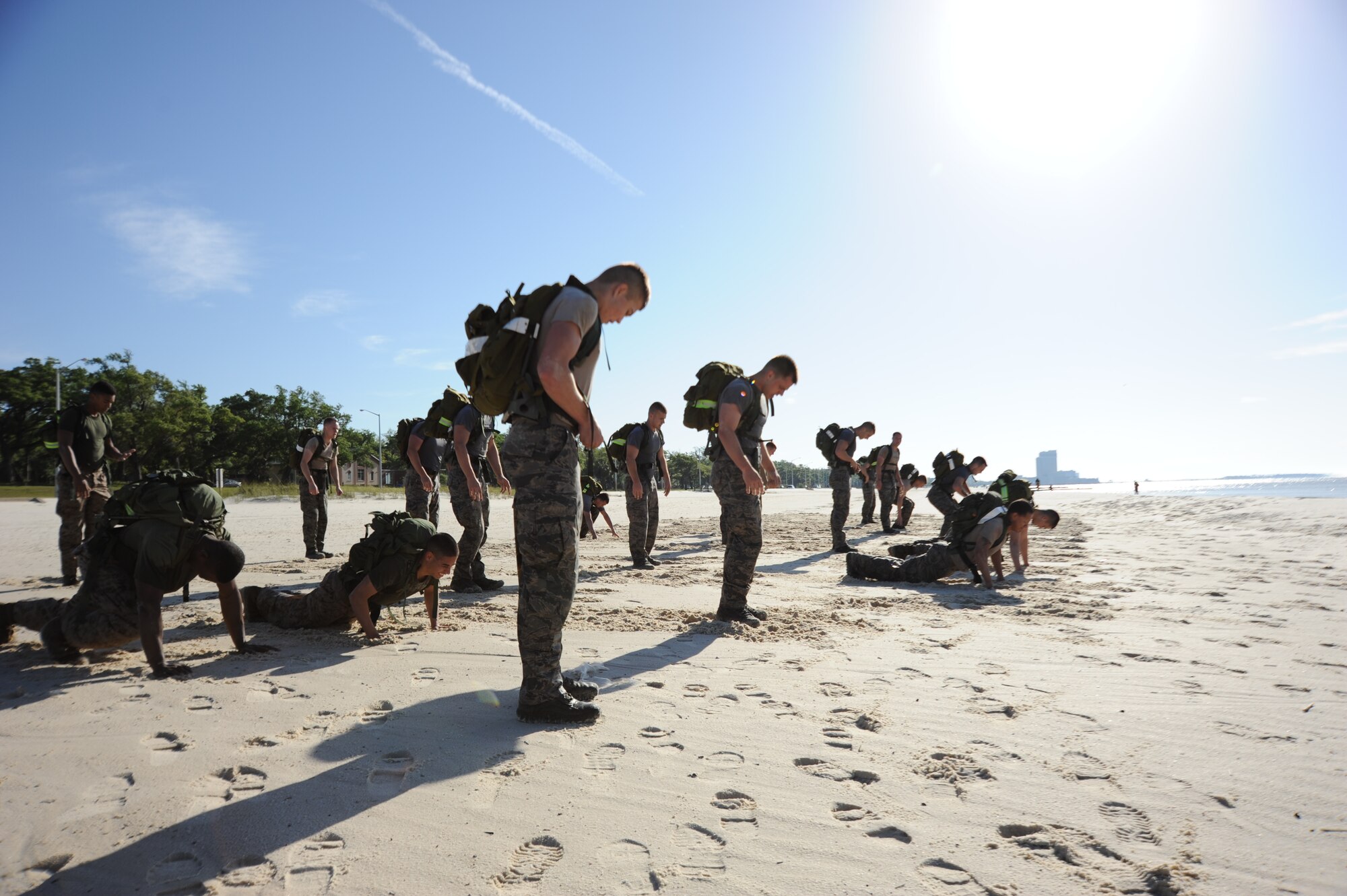 Combat control trainees from the 334th Training Squadron prepare to do push-ups during a physical training session April 12, 2013, on Biloxi beach. Combat controllers are ground troops who are embedded with special forces teams and provide close-air support for special forces units. While at Keesler, trainees learn how to run, swim, carry a rucksack and conduct air traffic control. These Airmen are prepared physically and mentally for the demands of the combat controller pipeline while earning air traffic control certification in just 15 weeks. (U.S. Air Force photo by 2nd Lt. Michael Alvarez)