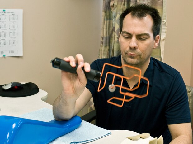James Looman, 57th Wing information assurance officer, does a range of motion exercise with a wrist wand April 3, 2013, at Nellis Air Force Base, Nev. The occupational therapy clinic uses a variety of tools for their treatments and exercises. (U.S. Air Force photo by Senior Airman Matthew Lancaster)