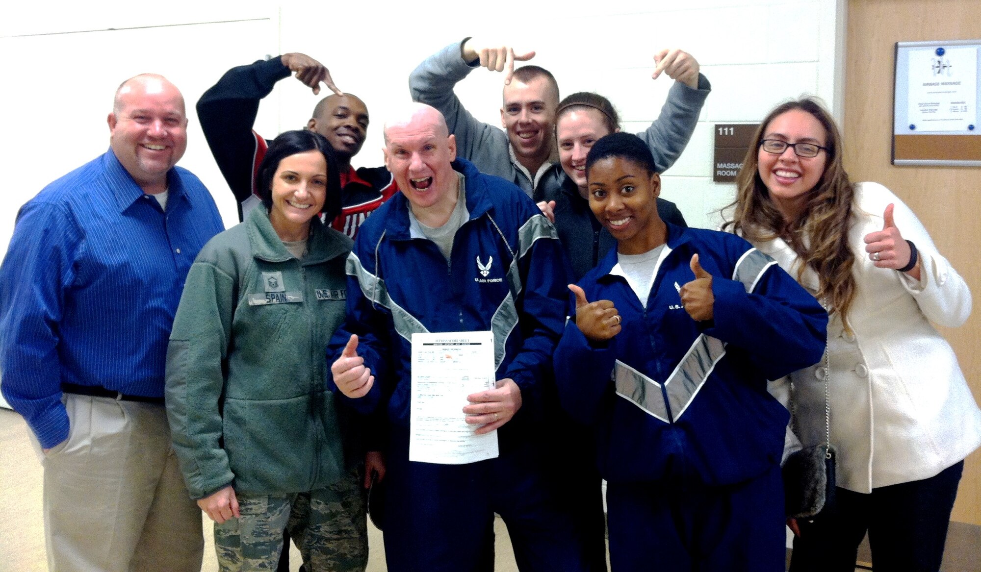 Tech. Sgt. Chuck Walker, 436th Airlift Wing Public Affairs, NCOIC of photojournalism, holds his passing Physical Training Test score sheet following his PT Test Feb. 24, 2013 at the fitness center on Dover Air Force Base, Del. Walker's co-workers from the PA shop were there to support and root Walker to victory. (Courtesty Photo)