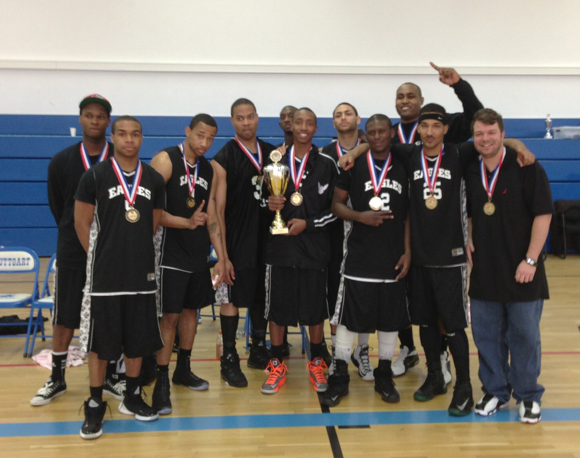 The RAF Mildenhall and RAF Lakenheath basketball team, the Eagles, proudly show off their trophy and medals after taking first place at the U.S. Air Forces in Europe/ Installation Management Command-Europe Basketball Championship in March 2013. Playing against 14 other teams from bases all around Europe, the Eagles played against Spangdahlem Air Base, Germany, in the final, bringing the trophy home to England. (Courtesy photo)