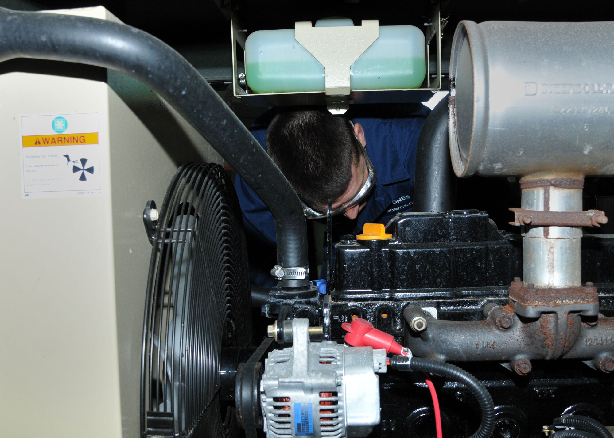 Chief Master Sgt.  Tracy Jones, 100th Air Refueling Wing command chief, changes the oil on an air compressor April 2, 2013, at building 528 on RAF Mildenhall, England. Jones and Col. Christopher Kulas, 100th ARW commander, visited the AGE shop as part of the base “dirty jobs” program. (U.S. Air Force photo by Airman 1st Class Kelsey Waters/Released)