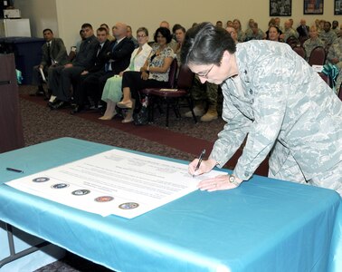 Brig. Gen. Theresa Carter, commander, Joint Base San Antonio and 502nd Air Base Wing, signs the Commanders’ Proclamation on Sexual Assault Awareness April 3 during the installation’s Sexual Assault Awareness Month observance at Warfighter and Family Readiness. (Photo by Mike O'Rear, JBSA-Fort Sam Houston Public Affairs)