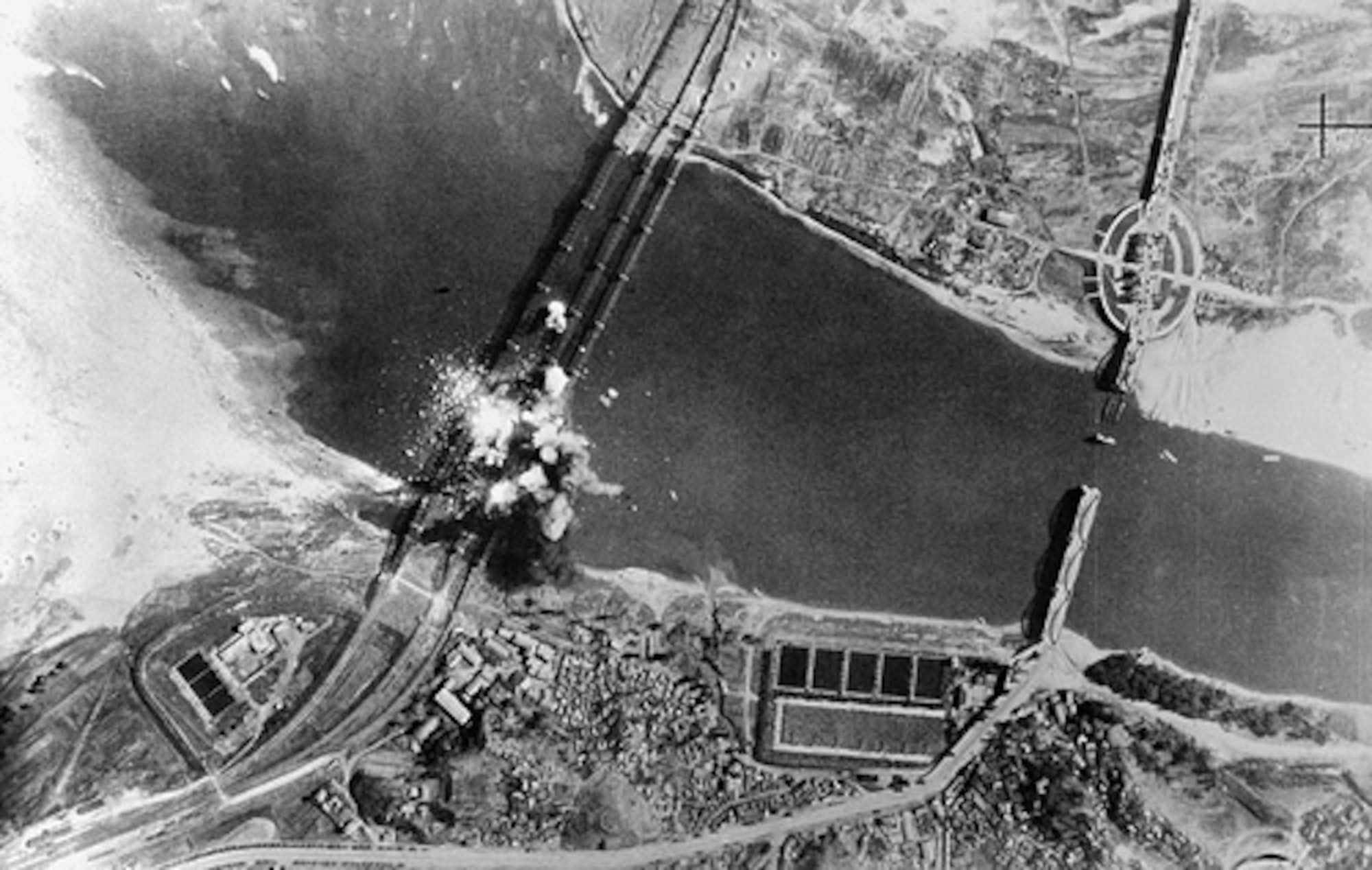 Air view of bombs dropped by U.S. Air Force, exploding on three parallel railroad bridges across Han River, southwest of Seoul, capital of the Republic of Korea. Bridges were bombed early in war to delay advance of invading North Korean troops. (DoD/National Air and Space Museum, #50-9025-306-PS)