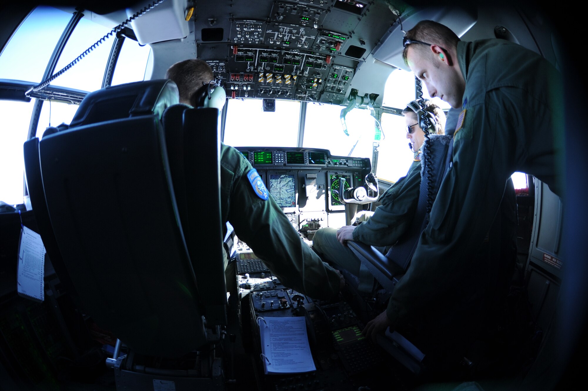 Capt. Christopher Boelscher (left), Maj. Dennis Hamilton (middle) and Capt. Matthew Schoomaker (right), 37th Airlift Squadron pilots, work together to fly more than 20 Airmen to Romania to participate in Exercise Carpathian Spring, April 14, 2013, Bucharest, Romania. The exercise runs through April 21 and is designed for aircrews to train as well as help build a partnership capacity with Romanians. (U.S. Air Force photo/Airman 1st Class Hailey Haux)
