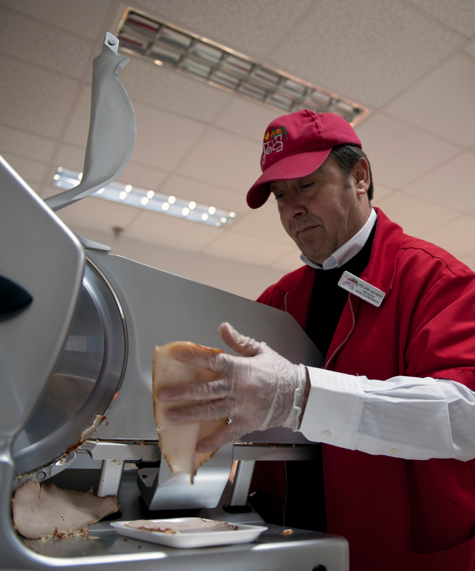 Selami Sahbaz, commissary employee, slices meat for a custom-made sandwich April 12, 2013, at Incirlik Air Base, Turkey. The Incirlik Commissary opened up a made-to-order sandwich shop in the deli for customers due to popular demand. (U.S. Air Force photo by Senior Airman Daniel Phelps/Released)