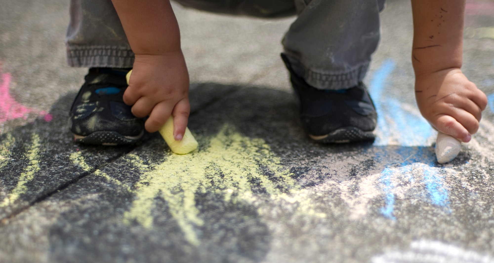 YOKOTA AIR BASE, Japan – A child draws on the sidewalk with chalk outside the base library at Yokota Air Base, Japan, April 15, 2013. Part of the Month of the Military Child, children were invited to the library for story time with chalk drawing afterwards. (U.S. Air Force photo by Staff Sgt. Chad C. Strohmeyer/Released)