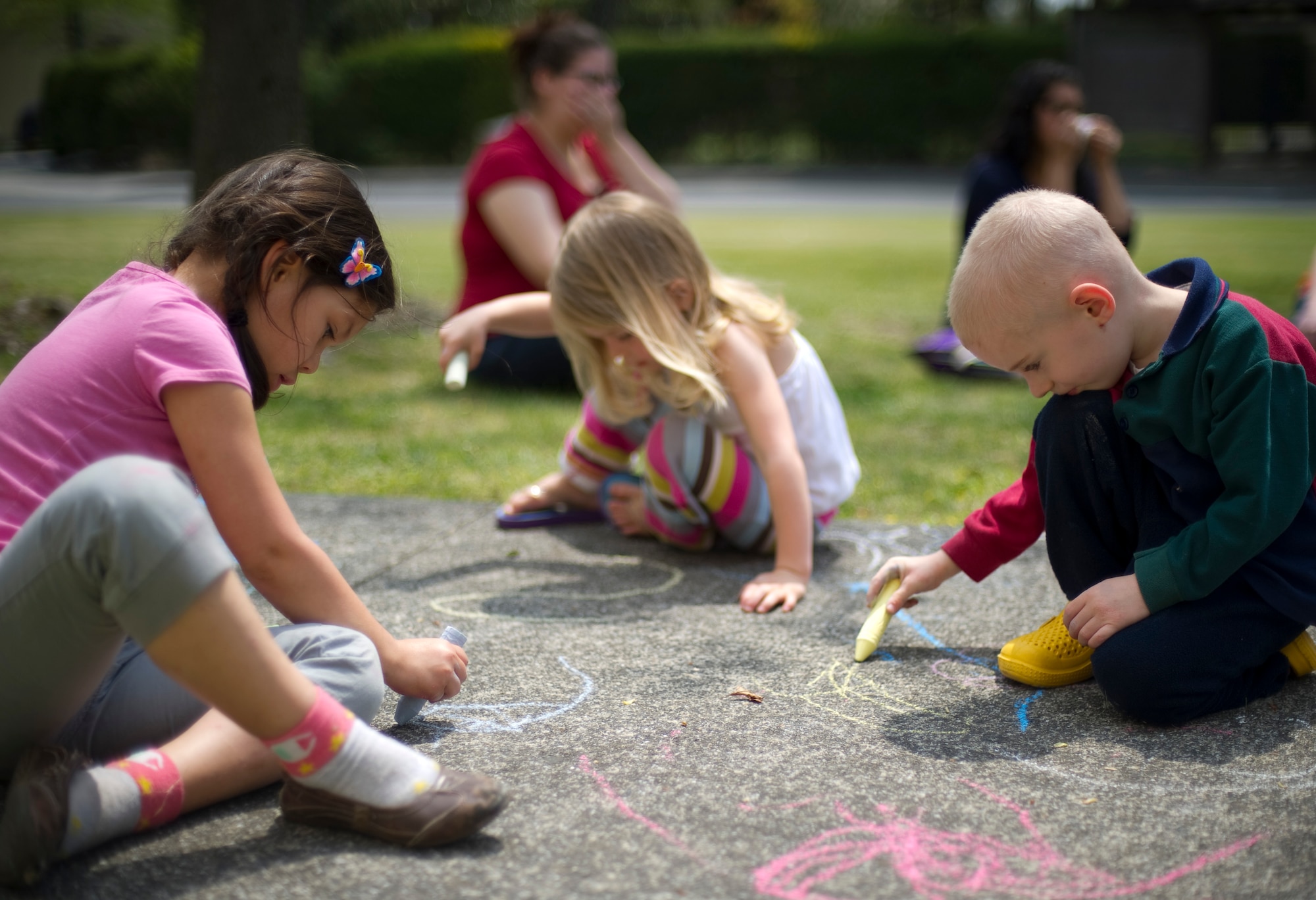 YOKOTA AIR BASE, Japan – Children draw on the sidewalk with chalk outside the base library at Yokota Air Base, Japan, April 15, 2013. Part of the Month of the Military Child, children were invited to the library for story time with chalk drawing afterwards. (U.S. Air Force photo by Staff Sgt. Chad C. Strohmeyer/Released)