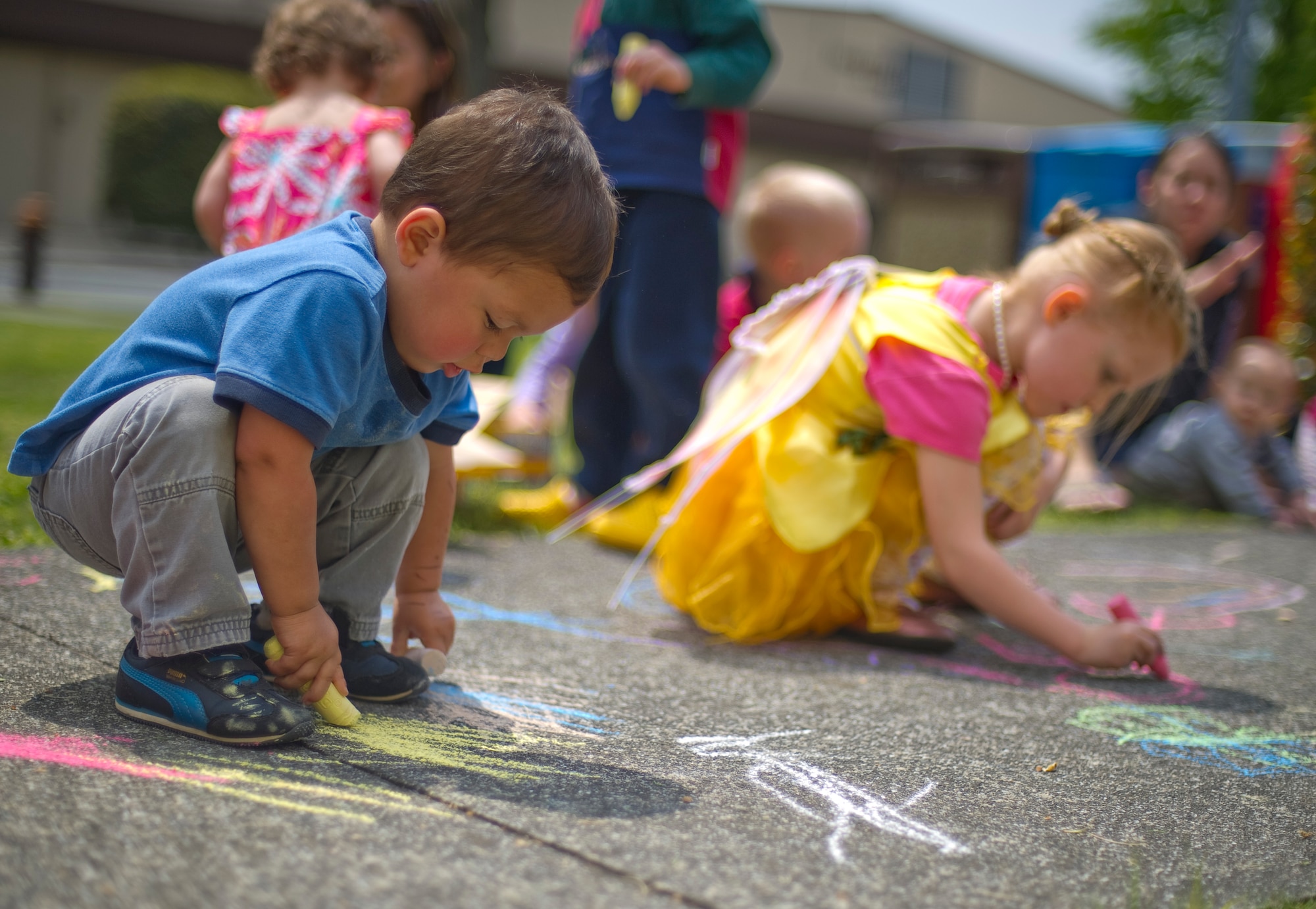 YOKOTA AIR BASE, Japan – Children draw on the sidewalk with chalk outside the base library at Yokota Air Base, Japan, April 15, 2013. Part of the Month of the Military Child, children were invited to the library for story time with chalk drawing afterwards. (U.S. Air Force photo by Staff Sgt. Chad C. Strohmeyer/Released)