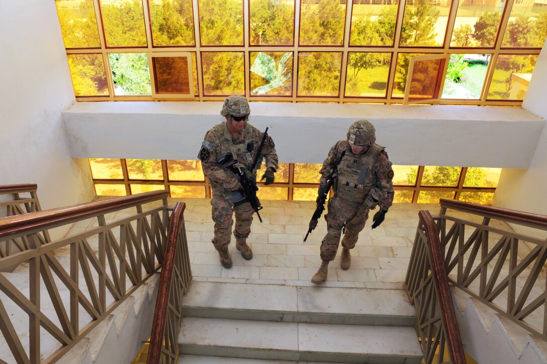 U.S. Army Capt. Jacob Estrada, left, and U.S. Navy Lt. Ronnie Mojzis walk down a staircase in the Farah provincial governor's office building after assessing damage during a meeting with the Farah provincial council in Farah City, Afghanistan, April 11, 2013. Estrada, a security force commander, and Mojzis, an engineer, are assigned to Provincial Reconstruction Team Farah.