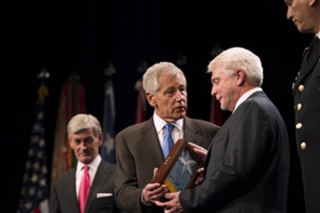 Secretary of Defense Chuck Hagel presents the Medal of Honor flag to Ray Kapaun at the ceremony to induct the nation’s latest Medal of Honor recipient Army Chaplain (Capt.) Emil J. Kapaun into the Pentagon’s Hall of Heroes on April 12, 2013.   Chaplain Kapaun died in a prisoner of war camp during the Korean War while counseling and saving countless fellow service members.  Ray is Chaplain Kapaun's nephew and represented his uncle during the ceremony.  