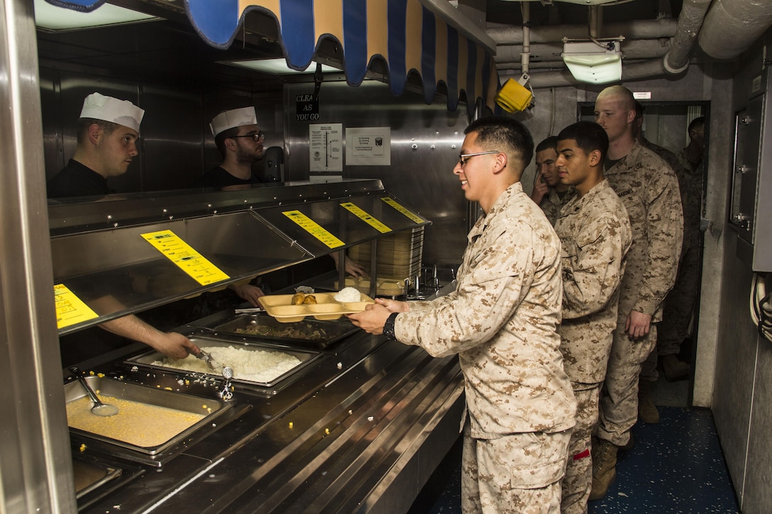 U.S. Marines and Sailors of the 26th Marine
Expeditionary Unit have dinner aboard the USS Carter Hall (LSD 50) while at sea April 14, 2013. The MEU is currently deployed as part of the Kearsarge Amphibious Ready Group to the 5th Fleet area of operation. The 26th MEU operates continuously across the globe, providing the president and unified combatant commanders with a forward-deployed,  sea-based quick reaction force. The MEU is a Marine Air-Ground Task Force capable of conducting amphibious operations, crisis response and limited contingency operations. 
(U.S. Marine Corps photo by Cpl. Michael S.
Lockett/Released)