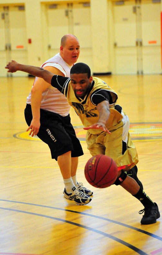 Aaron Johnson, a player for CI AIB, lunges for control of the ball during a National League intramural game against AFOSI on April 11, 2013. CI AIB outran and outscored AFOSI 45 - 34 and held onto their third seed in the league while AFOSI dropped to eigth in the league.