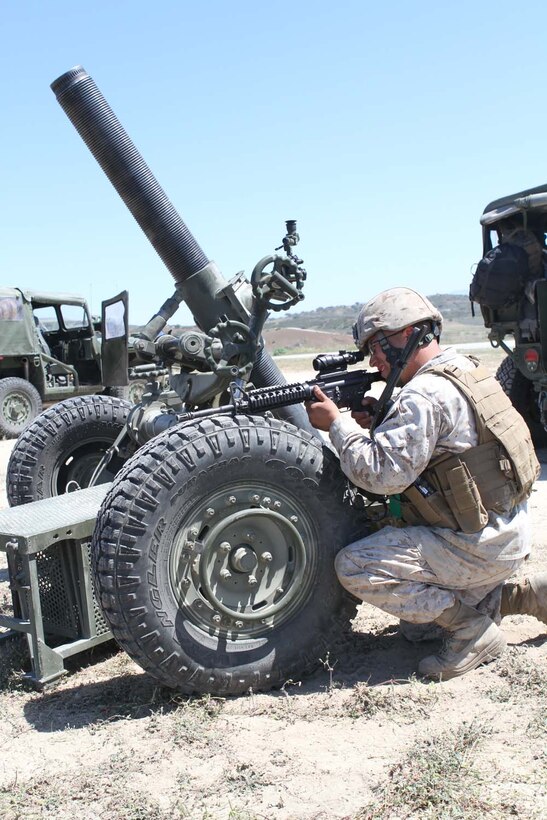 MARINE CORPS BASE CAMP PENDLETON, Calif. – Corporal Adrian Gonzalez, a field artillery cannoneer and a gun chief serving with Echo Battery, 2nd Battalion, 11th Marine Regiment, provides security against a simulated enemy attack during a live-fire training exercise here, April 3, 2013. Gonzalez, a 28-year-old-native of Los Angeles, said being a great field artillery cannoneer doesn’t mean all you have to learn is artillery. He said he had to learn how to operate as an infantry rifleman as well.