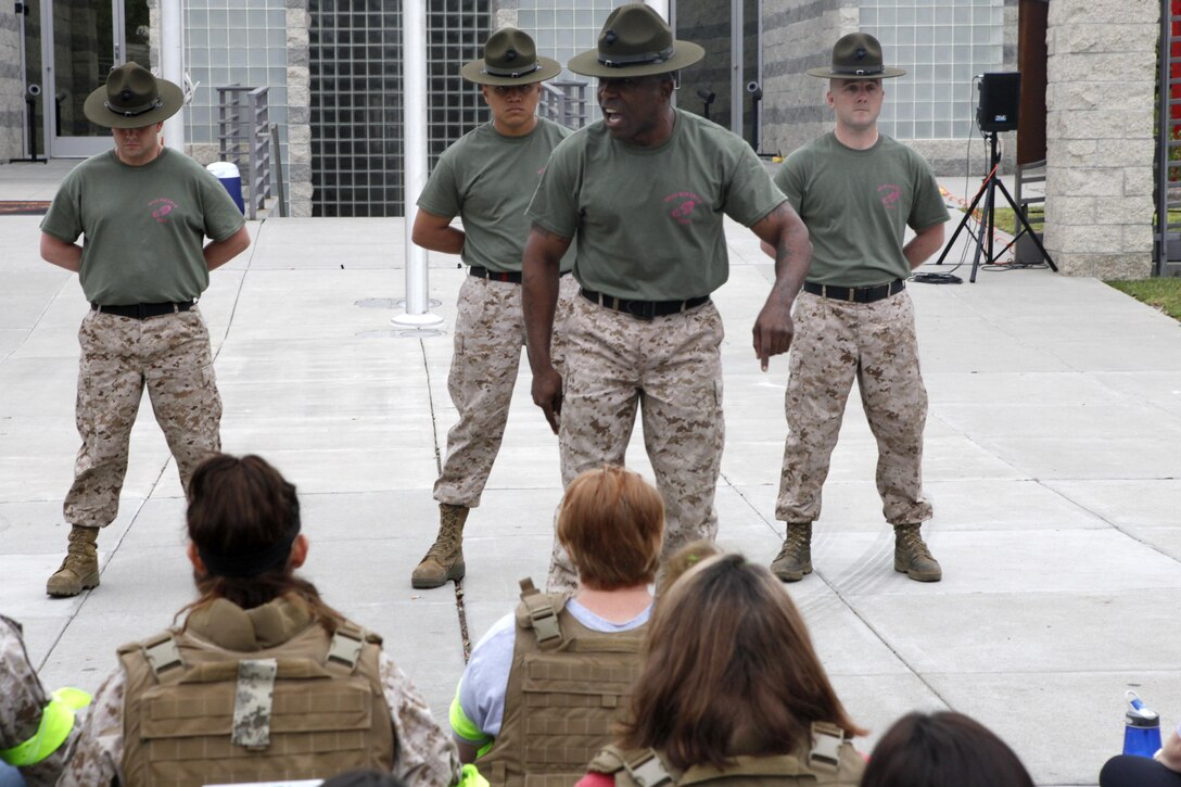Drill instructors give a speech to Marine Aircraft Group 16 wives during a Jane Wayne Day event aboard Marine Corps Air Station Miramar, Calif., April 13. The spouses also rode in 7-ton trucks, learned Marine Corps martial arts moves and shot simulated weapons.