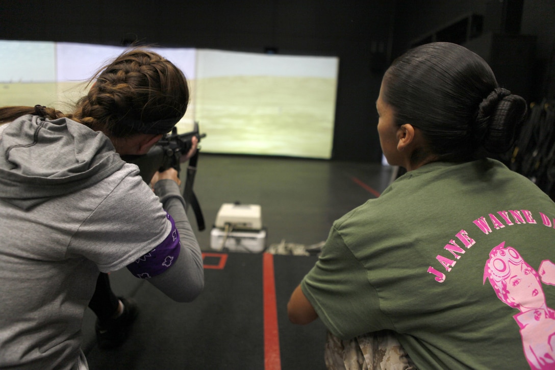 Vina Combellick, wife of a pilot with Marine Heavy Helicopter Squadron 462, left, shoots an M-16A4 service rifle during a Jane Wayne Day event aboard Marine Corps Air Station Miramar, Calif., April 13. Jane Wayne day teaches Marine Corps spouses some aspects of what their Marines do each day.