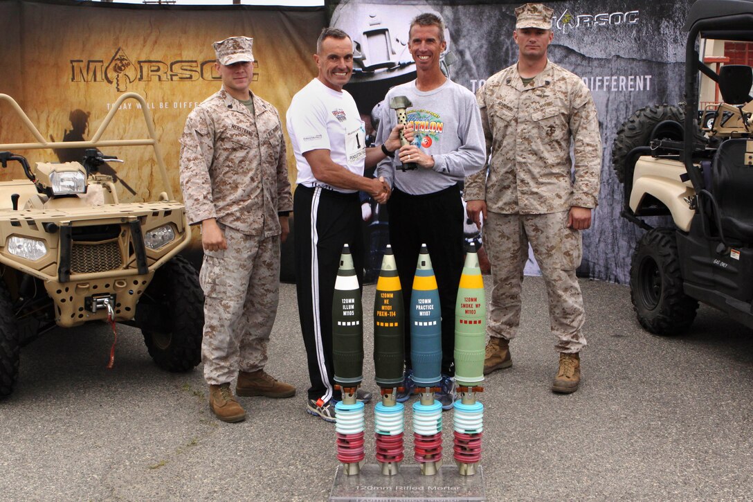 Brig. Gen. Vincent A. Coglianese, center-left, presents Frederick Herr the overall first place trophy during the Heartbreak Ridge Marathon here April 13. Herr, 46-years-old, finished overall first place in 1 hour, 17 minutes and 40 seconds. Coglianese is the base commanding general and the regional authority for five military installations in the southwestern United States. 