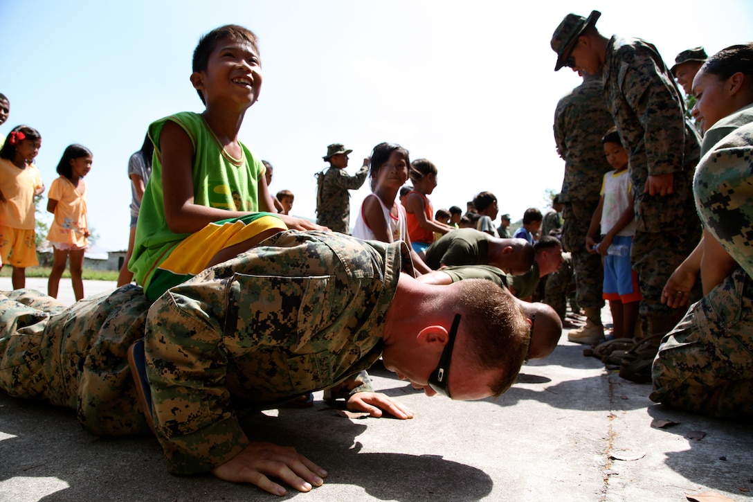 U.S. Marine Sgt. Aaron M. Blackstone competes in a push-up competition during a community relations event April 12 at Maruglo Elementary School in Capas, Tarlac, Republic of the Philippines. Armed Forces of the Philippines Marines, and U.S. Marines and sailors visited the school to play games with the children as well as drop off educational supplies. The service members are currently participating in Balikatan 2013, an annual bilateral exercise in its 29th iteration, which provides a venue for the AFP and U.S. militaries to develop and continue to enhance interoperability across a wide range of military actions. Blackstone is a refrigeration mechanic with 3rd Maintenance Battalion, Combat Logistics Regiment 35, 3rd Marine Logistics Group, III Marine Expeditionary Force and a Newark, Ohio native