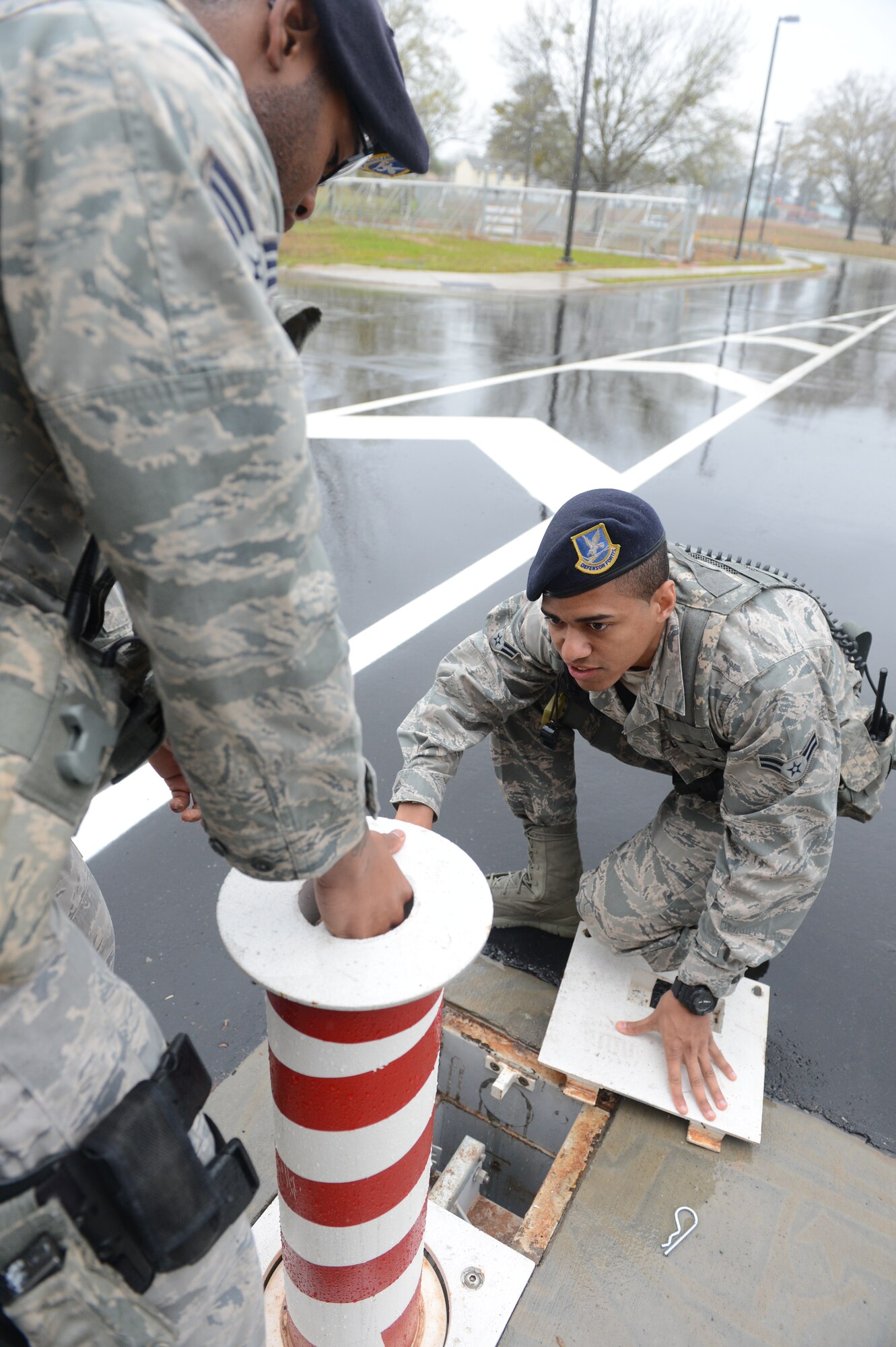 Airman 1st Class Dwayne Bolden, 20th Security Forces Squadron entry controller, and Senior Airman Tahy Addison, 20th SFS patrolman, raise the road guards at one of the gates at Shaw Air Force Base, S.C., April 5, 2013. There are multiple facets of security forces in addition to patrolmen and entry controllers that work together to complete its mission to safeguard the base and its assets. There are also investigations, combat arms and the military working dogs sections. (U.S. Air Force photo by Airman 1st Class Krystal M. Jeffers/Released)