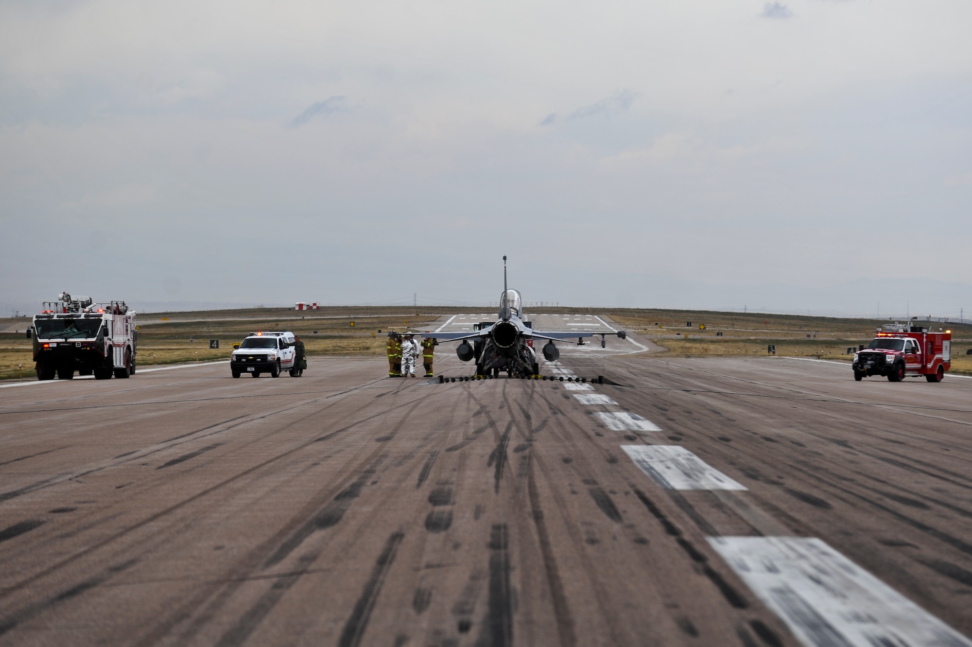 Buckley firefighters respond to a Colorado Air National Guard F-16 Fighting Falcon while testing a newly installed Barrier Arresting Kit-12 system April 12, 2013, on the flightline at Buckley Air Force Base, Colo. Airmen from the 460th Civil Engineer Squadron, 140th CES, Colorado Air National Guard, and 200th RED HORSE, Ohio National Guard, installed two BAK-12 systems in preparation for upcoming flightline construction. (U.S. Air Force photo by Airman 1st Class Riley Johnson/Released)