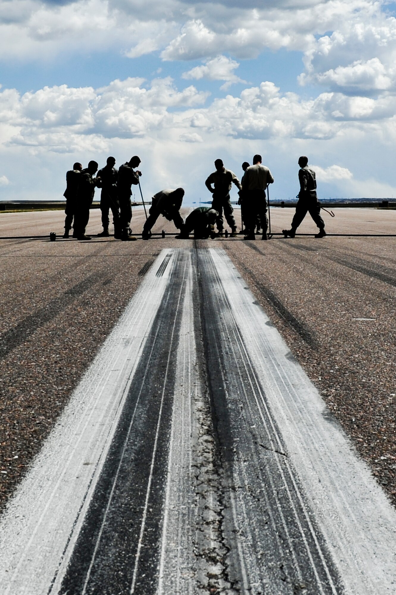 Airmen from the 460th Civil Engineer Squadron, 140th CES, Colorado Air National Guard, and 200th RED HORSE, Ohio National Guard, install a Barrier Arresting Kit-12 system April 12, 2013, on the flightline at Buckley Air Force Base, Colo. Eight Airmen from 200th Rapid Engineer Deployable Heavy Operational Repair Squadron Engineers provided Buckley’s power production teams with manpower, assets and expertise in the assembly and installation of two BAK-12 systems. (U.S. Air Force photo by Airman 1st Class Riley Johnson/Released)