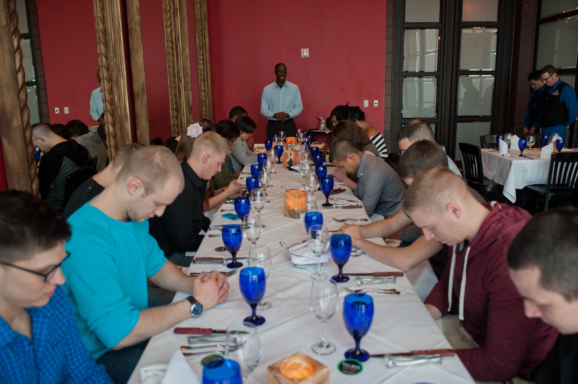 Capt. Henry Jenkins, 28th Bomb Wing chaplain, leads Airmen in prayer before receiving a meal at Texas de Brazil during a spiritual resiliency singles retreat in Denver, April 8, 2013. The Ellsworth chapel has a marriage retreat for 21 couples planned for April 18 – 21, in Denver. For more information or to sign up for the next retreat, call the 28th BW Chapel at (605) 385-1598. (U.S. Air Force photo by Airman 1st Class Zachary Hada/Released)
