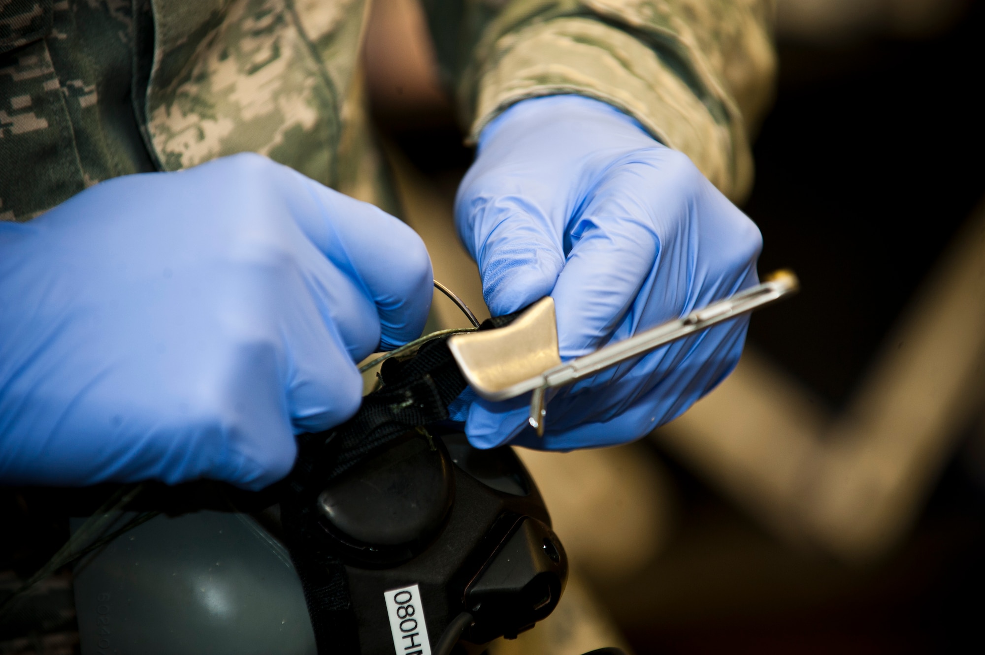 Airman Alexander Pretriuc, U.S. Air Force Weapons School aircrew flight equipment apprentice, tacks an oxygen mask April 15, 2013, at Nellis Air Force Base, Nev. Tacking is a method used to maintain and secure fit sizes to an aircrew member's face. (U.S. Air Force photo/Senior Airman Brett Clashman)