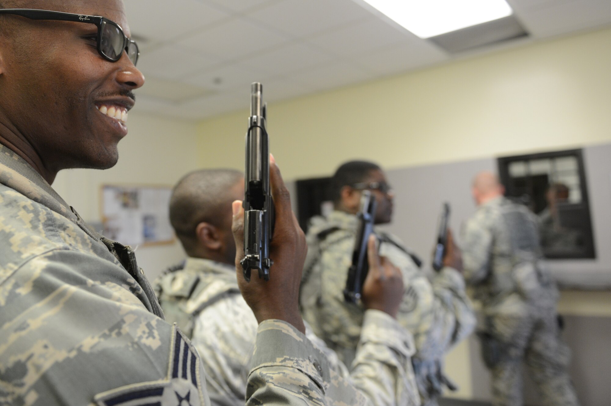 Senior Airman Jeffrey Wilson, 20th Security Forces Squadron patrolman, and other members of 20th SFS return their M-9 Berettas to the armory at Shaw Air Force Base, S.C., after their shift, April 5, 2013. Security forces’ mission is to secure and defend Shaw and its assets. The patrolmen’s part in that mission is keeping law and order on base by enforcing standards of conduct and discipline along with state, military and federal laws. (U.S. Air Force photo by Airman 1st Class Krystal M. Jeffers/Released)