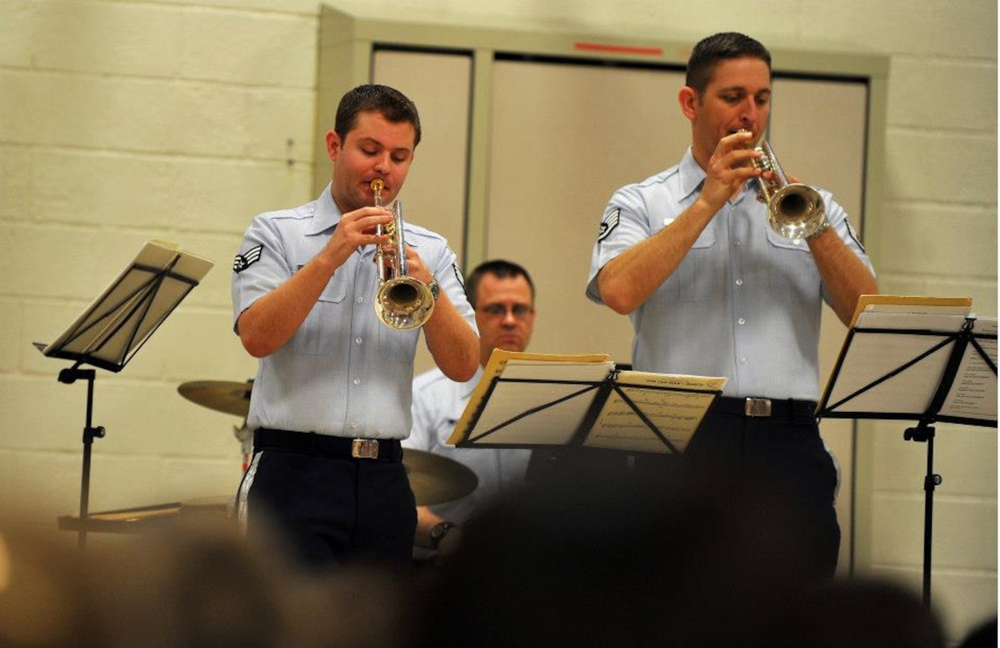 Airman First Class Tim Schleinat and Staff Sergeant Carl Eitzen perform on the trumpet and Technical Sergeant James Mangette performs on percussion with Offutt Brass for local elementary school students