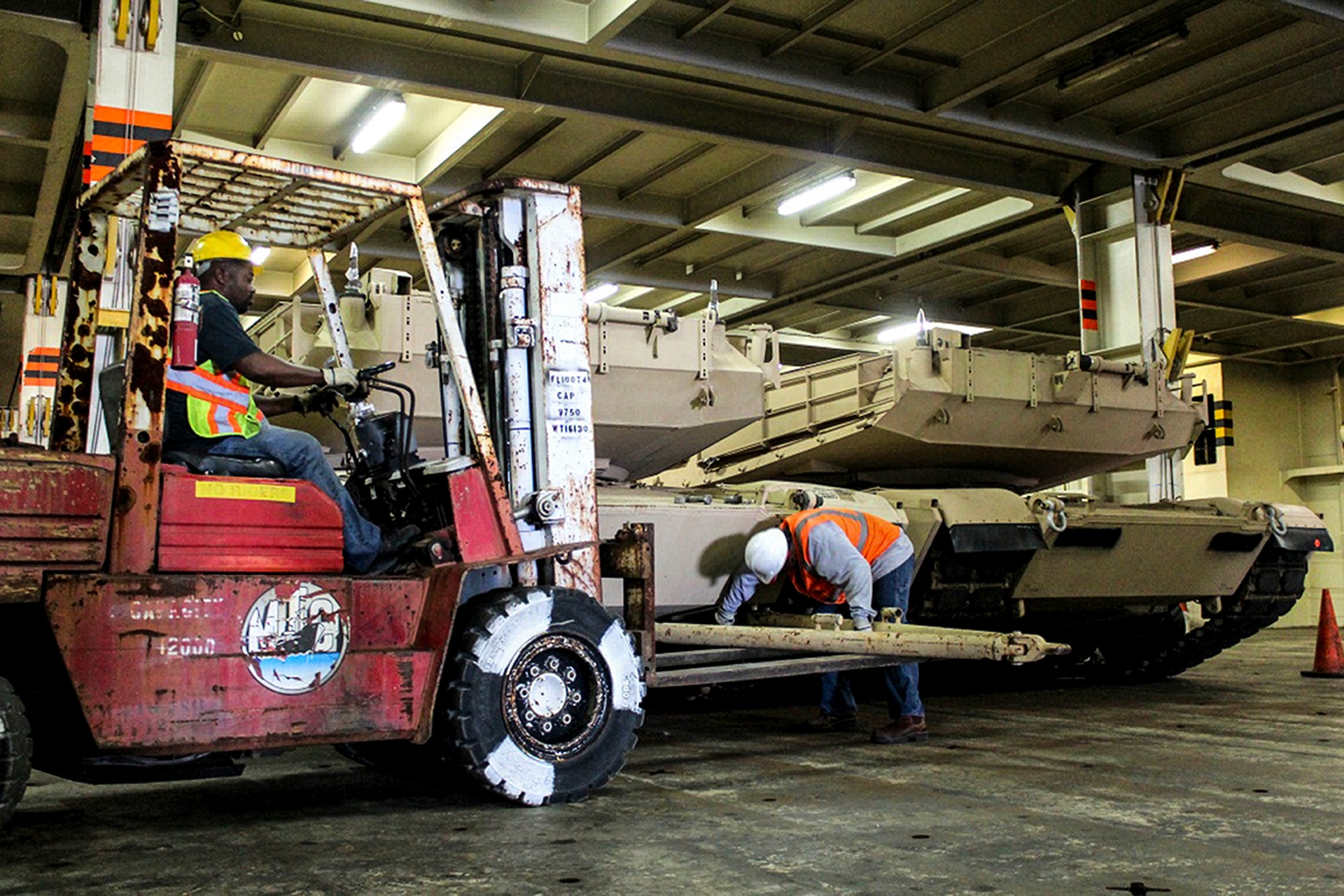 Contractors work to attach a tow bar onto an Abrams tank to pull out of the Honor of Arc, an American roll-on and roll-off vessel April 10, 2013, at the TC Dock at Joint Base Charleston – Weapons Station, S.C. The 841st Transportation Battalion received and offloaded the final shipment of Abrams battle tanks to be moved to the West Coast.  It ended the 69-year history of the United States Army having their main battle tanks on German soil. (U.S. Army photo/SGT Marcellus Beavers)  