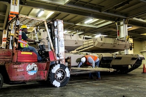 Contractors work to attach a tow bar onto an Abrams tank to pull out of the Honor of Arc, an American roll-on and roll-off vessel April 10, 2013, at the TC Dock at Joint Base Charleston – Weapons Station, S.C. The 841st Transportation Battalion received and offloaded the final shipment of Abrams battle tanks to be moved to the West Coast.  It ended the 69-year history of the United States Army having their main battle tanks on German soil. (U.S. Army photo/SGT Marcellus Beavers)  