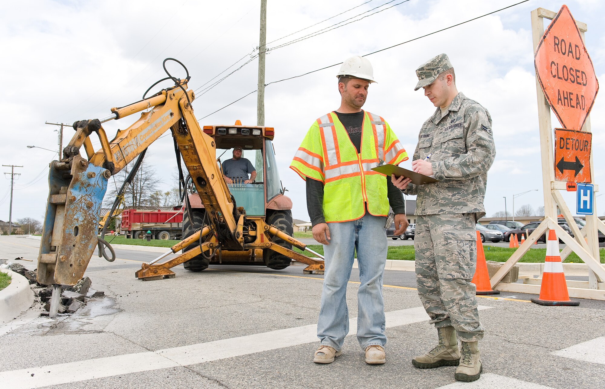 Airman 1st Class George De Young, right, a contract specialist with the 436th Contracting Squadron, talks with Ryan Meisinger, a concrete finisher with Mitten Construction Company, April 16, 2013, at Dover Air Force Base, Del. De Young conducted a site visit for the purpose of a labor interview to ensure the contractor is in compliance with the regional Davis-Bacon Act wage determination. (U.S. Air Force photo/Roland Balik)