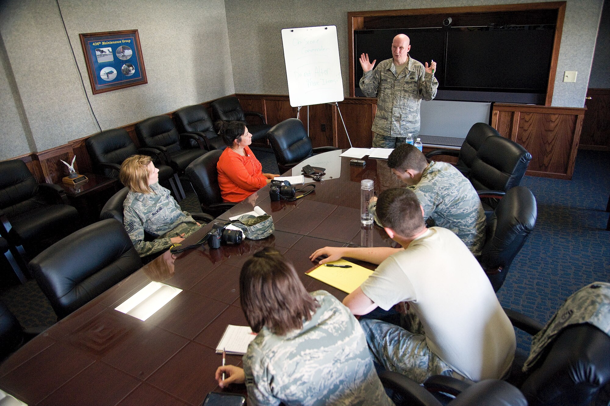 Technical Sgt. Charles Walker, 436th Airlift Wing Public Affairs NCOIC photojournalism, standing, reviews how to approach a crime scene as a alert photographer with military members of the 436th and 512th Airlift Wing's Public Affairs sections as they undergo specialized training to prepare them to respond to alert and investigative response photography needs at Dover Air Force Base, Del., April, 11, 2013. After completing classroom portions of the training, each person was sent to respond to a staged accident/crime scene and tasked with fully documenting the details. (U.S. Air Force photo/Greg L. Davis)