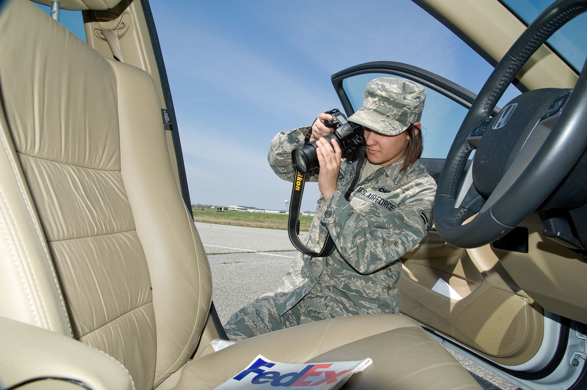 Airman 1st Class Ashlin Federick, 436th Airlift Wing Public Affairs photojournalist, documents details found inside the car door of a staged accident scene as part of hands-on training, Dover Air Force Base, Del., April 11, 2013. Military members of the 436th and 512th Airlift Wing's Public Affairs sections undertook specialized training to prepare them to respond to alert and investigative response photography needs at Dover Air Force Base, Del. recently. After completing classroom portions of the training, each person was sent to respond to a staged accident/crime scene and tasked with fully documenting the details. (U.S. Air Force photo/Greg L. Davis)