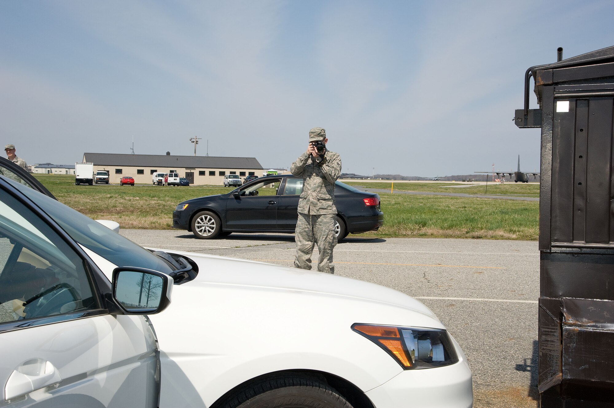 Senior Airman Jarod Duhon, 436th Airlift Wing Public Affairs photojournalist, documents a staged accident scene as part of hands-on training, Dover Air Force Base, Del., April 11, 2013. Military members of the 436th and 512th Airlift Wing's Public Affairs sections undertook specialized training to prepare them to respond to alert and investigative response photography needs at Dover Air Force Base, Del. recently. After completing classroom portions of the training, each person was sent to respond to a staged accident/crime scene and tasked with fully documenting the details. (U.S. Air Force photo/Greg L. Davis)