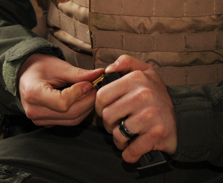 Maj. Adam Newell, 2nd Aerospace Medical Squadron flight surgeon, loads rounds into a magazine during an M-9 Air Force Qualification Course on Barksdale Air Force Base, La., April 16, 2013. Airmen are given 90 rounds to shoot. Half the rounds are used for practice and the other half are used for qualification. (U.S. Air Force photo/Senior Airman Sean Martin) (RELEASED)