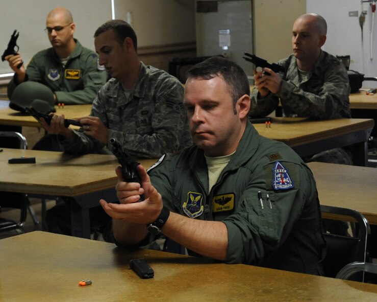 Maj. Adam Price, 11th Bomb Squadron instructor pilot, practices a reload during an M-9 qualification class on Barksdale Air Force Base, La., April 16, 2013. Airmen shoot 90 rounds of ammunition at targets using various shooting positions and must obtain a minimum score 35 shots on paper to pass. (U.S. Air Force photo/Senior Airman Sean Martin)