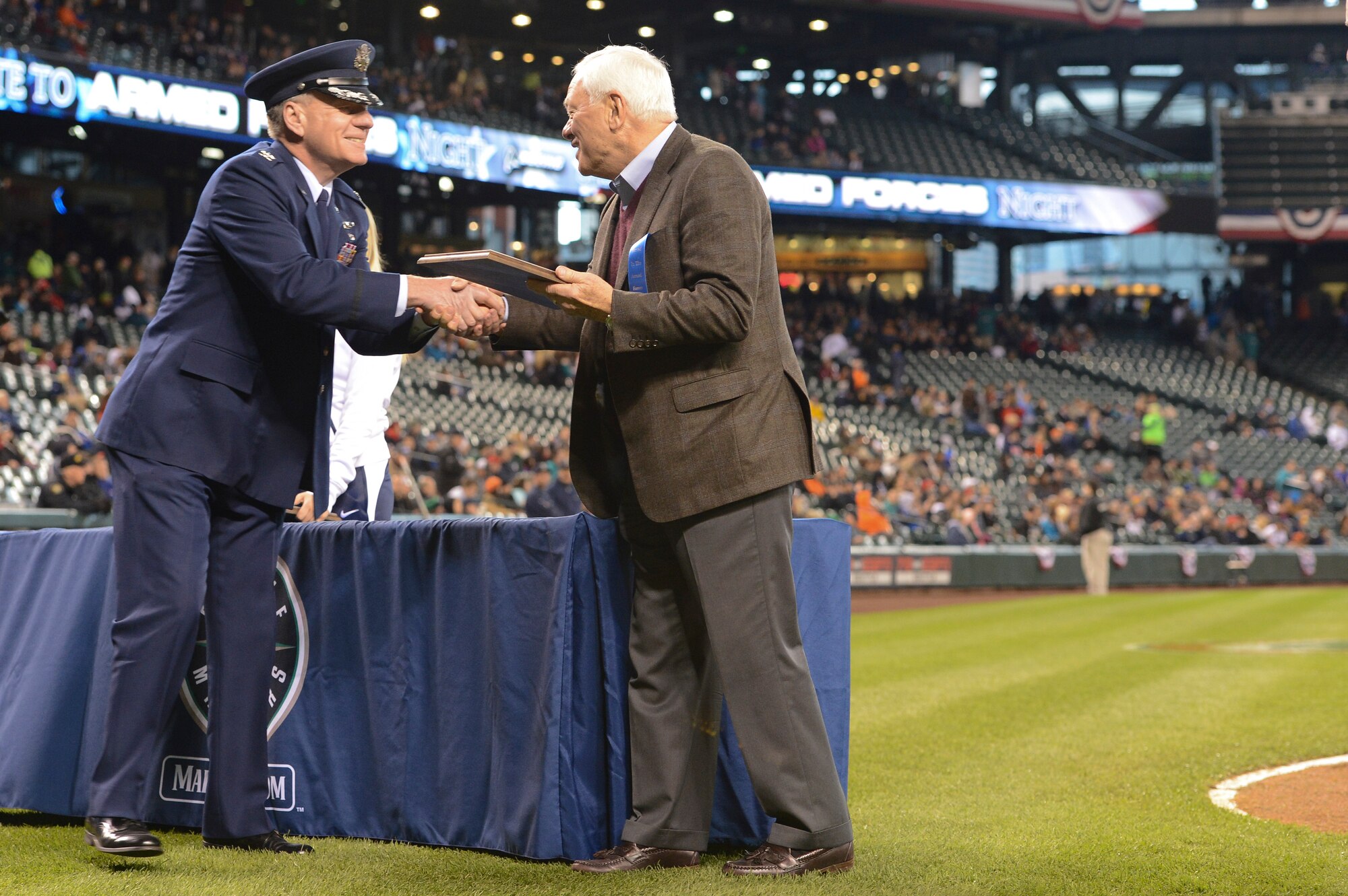 Col. Bruce Bowers Jr., 446th Airlift Wing commander, is presented a plaque by Chuck Armstrong, Seattle Mariners president, April 13, 2013, at Safeco Field in Seattle, Wash. Bowers was invited to participate in the opening ceremonies for the team's annual Salute to Armed Forces Night. (U.S. Air Force photo/Tech. Sgt. Sean Tobin)