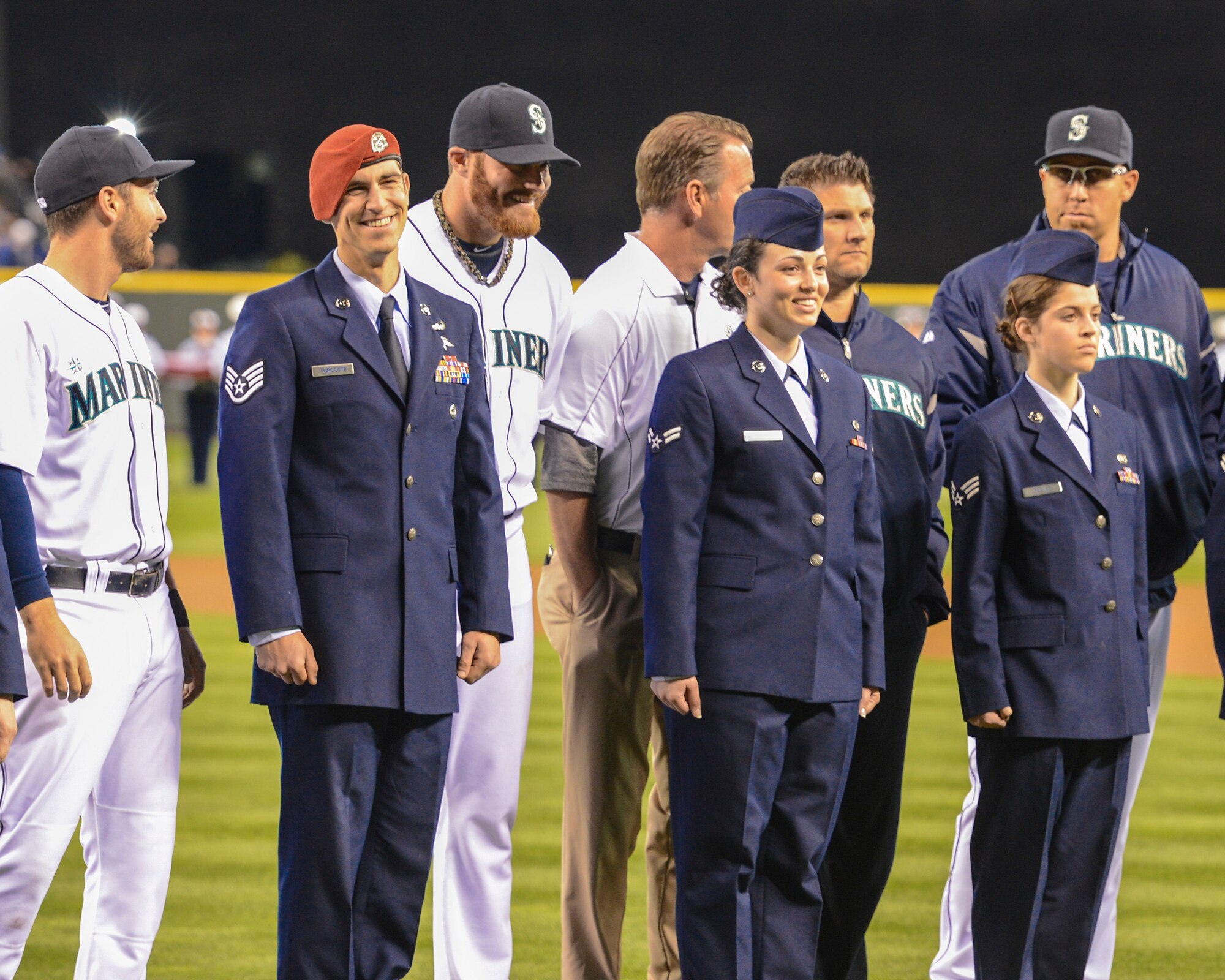Airmen from the 62nd Airlift Wing joke with members of the Seattle Mariners, April 13, 2013, following the opening ceremonies of the baseball team’s annual Salute to Armed Forces Night in Seattle, Wash. The Airmen were selected to stand on the baselines with the players during the event's ceremonies, which featured participation from service members from all military branches. (U.S. Air Force photo/Tech. Sgt. Sean Tobin)
