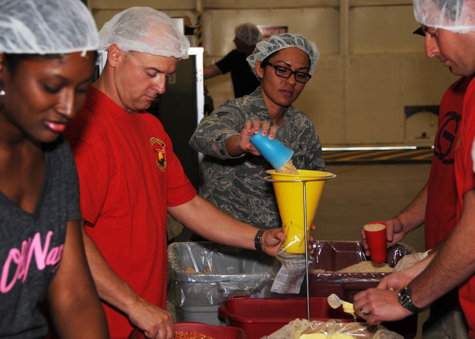 Luke Air Force Base volunteers worked April 6 to package meals to send to Afghanistan to feed hungry children. The food is provided by Food for Kidz and the packages are a mixture of rice, soy flour, dehydrated vegetables, vegan protein powder and spices which are sealed in industrial-grade plastic bags and have a shelf life of seven years. (U.S. Air Force photo/Tech. Sgt. Louis Vega Jr.)
