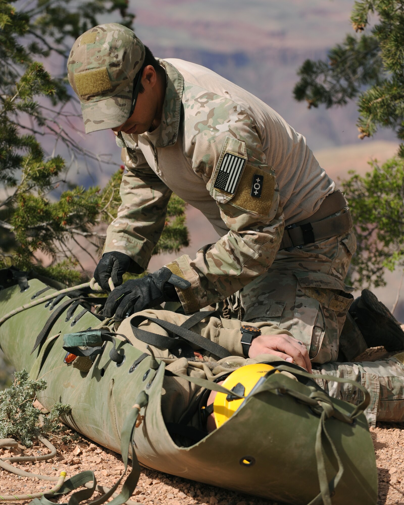 A U.S. Air Force pararescueman from the 58th Rescue Squadron, Nellis Air Force Base, Nev. tightens a casualty’s straps for transportation as part of Angel Thunder at the Grand Canyon,  April 13, 2013. Angel Thunder is the largest joint service, multinational, interagency combat search and rescue exercise in the world. It is designed to train personnel recovery assets using a variety of scenarios to simulate deployment conditions and contingencies.  (U.S. Air Force photo by Airman 1st Class Christine Griffiths/Released)