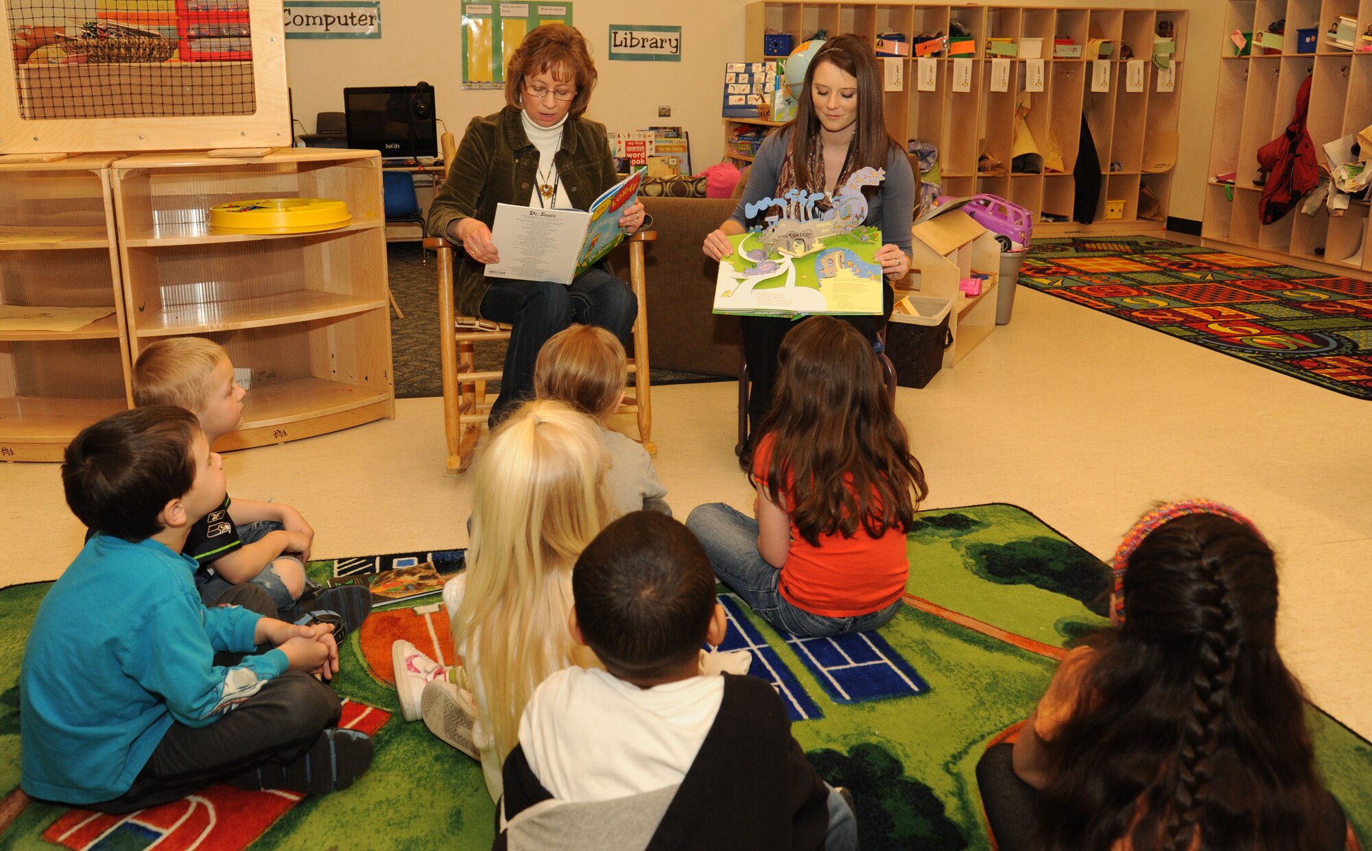 A kindergarten class listens to the story of the Lorax, in celebration of Earth Day, at the Child Development Center, Fairchild Air Force Base, Wash. April 10, 2013. The children are also planting flowers to place around the CDC. (U.S. Air Force photo by Senior Airman Samantha Krolikowski)