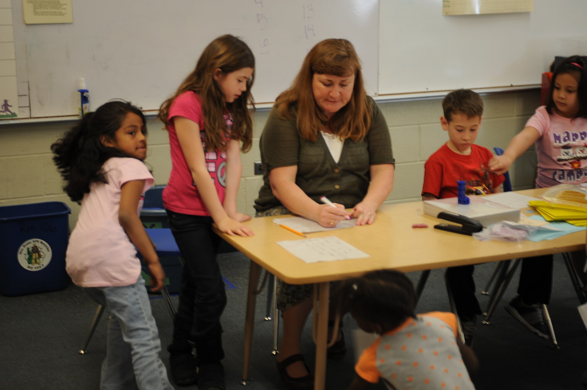 A teacher assists students with class work April 3, 2013, at Mountain Home Air Force Base, Idaho. Students are currently celebrating Month of the Military Child by making posters and signs for display throughout the school. (U.S. Air Force photo by Senior Airman Benjamin Sutton/Released)