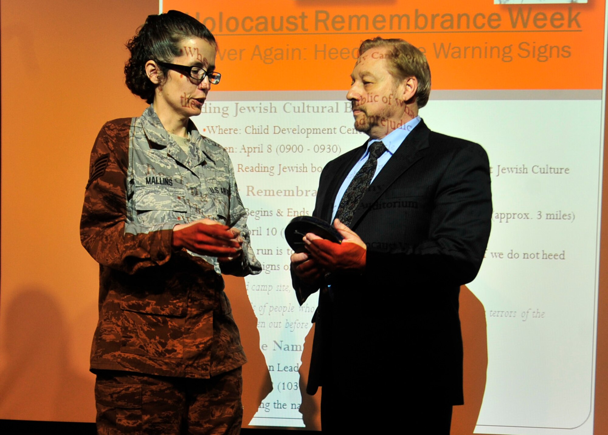 Steve Gonzer receives a gift from Tech. Sgt. Patricia Mallins, 436th Aerospace Medical Squadron and member of the Holocaust Remembrance committee, following Gonzer’s speech at the Holocaust Remembrance Ceremony April 12, 2013, at Dover Air Force Base, Del. Gonzer encouraged those present to remember the approximate 6.1 million victims of the Holocaust. (U.S. Air Force photo/Tech. Sgt. Chuck Walker)
