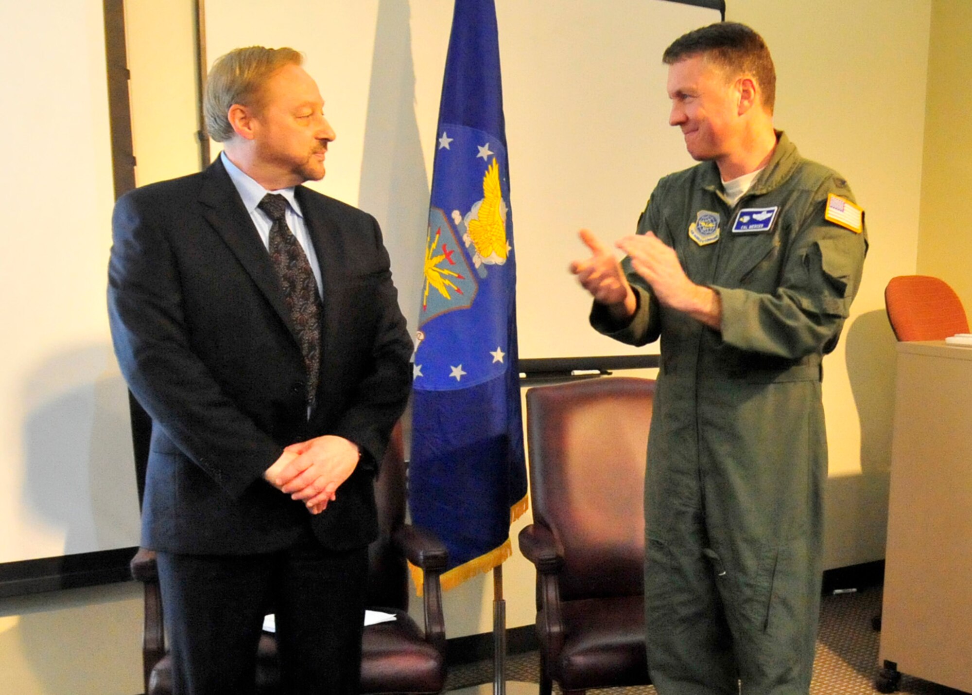 Steve Gonzer, documentary filmmaker, receives applause from Col. Cal Mercer, 436th Airlift Wing deputy commander, following his speech at the Holocaust Remembrance Ceremony April 12, 2013, at Dover Air Force Base, Del. Gonzer spoke of the need for everyone to remember the victims of the Holocaust.