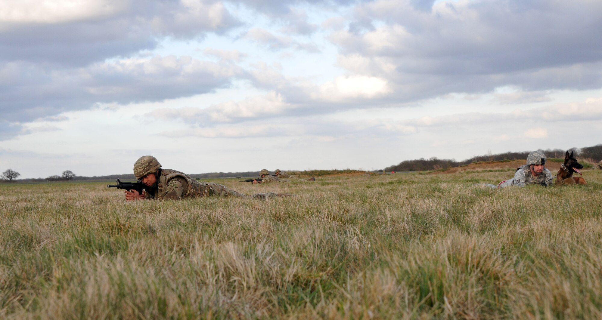 From left, Tongan Defence Force Pvt. Fatafehi Tokomaata, Contingent 6, and other members of the TDF practice looking for roadside bombs with Staff Sgt. Christopher Bieu, 100th Security Forces Squadron military working dog handler from Newington, Conn., and MWD Vvonya April 15, 2013, at RAF Honington, England. The training was part of a semi-annual familiarization course on night vision goggles, different sights and how to work with a MWD team. (U.S. Air Force photo by Airman 1st Class Kelsey Waters/Released)