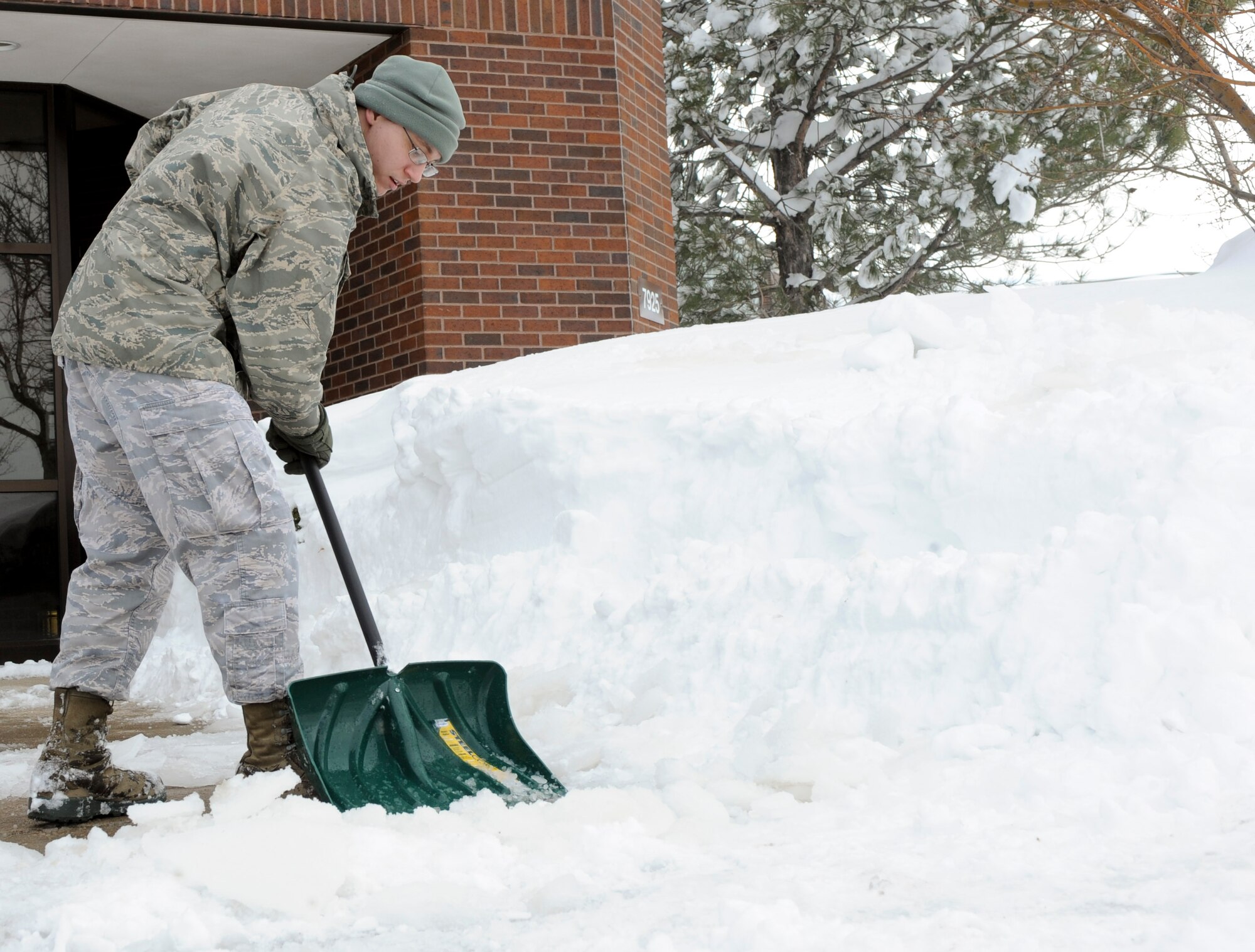 Senior Airman Matthew Begeman, 28th Operation Support Squadron intelligence weapons and tactics technician, shovels snow off of the sidewalk outside the 28th Bomb Wing Headquarters building at Ellsworth Air Force Base, S.D., April 11, 2013. Winter storm Walda hit Box Elder and the surrounding areas, leaving Ellsworth with approximately 21 inches of snow after two days. (U.S. Air Force photo by Airman 1st Class Anania Tekurio/Released)