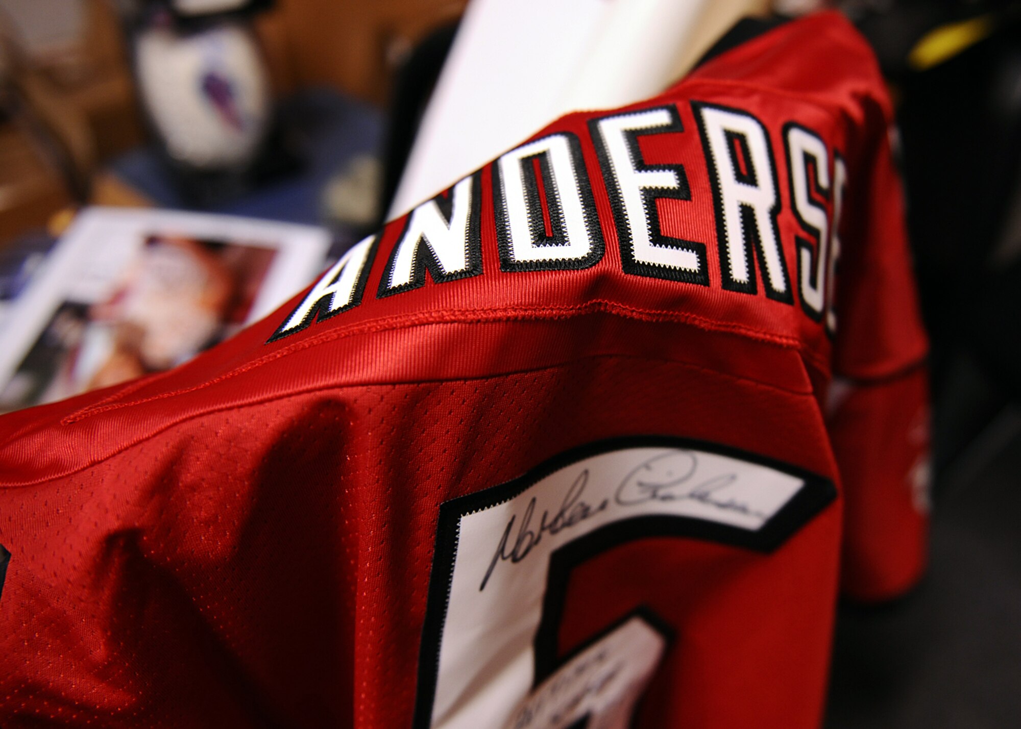 SPANGDAHLEM AIR BASE, Germany – An autographed Morten Andersen jersey hangs on a chair April 10, 2013. Andersen, a kicker, is the all-time leading scorer in NFL history. The jersey is part of the Operation Warm Heart silent auction 10 a.m. – 6 p.m., May 31 in the Brick House. U.S. Air Force Master Sgt. Anthony Mitchell, 52nd Logistics Readiness Squadron assistant first sergeant and Spangdahlem First Sergeant Council fundraising chairperson, created the auction to raise funds for the program. (U.S. Air Force photo by Staff Sgt. Daryl Knee/Released)